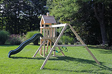 Small cedar swing set weith 3 swings and a slide.