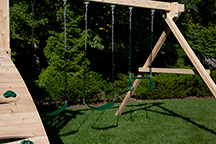 Triumph Play System's Kelton Climber cedar swing set with three swings.